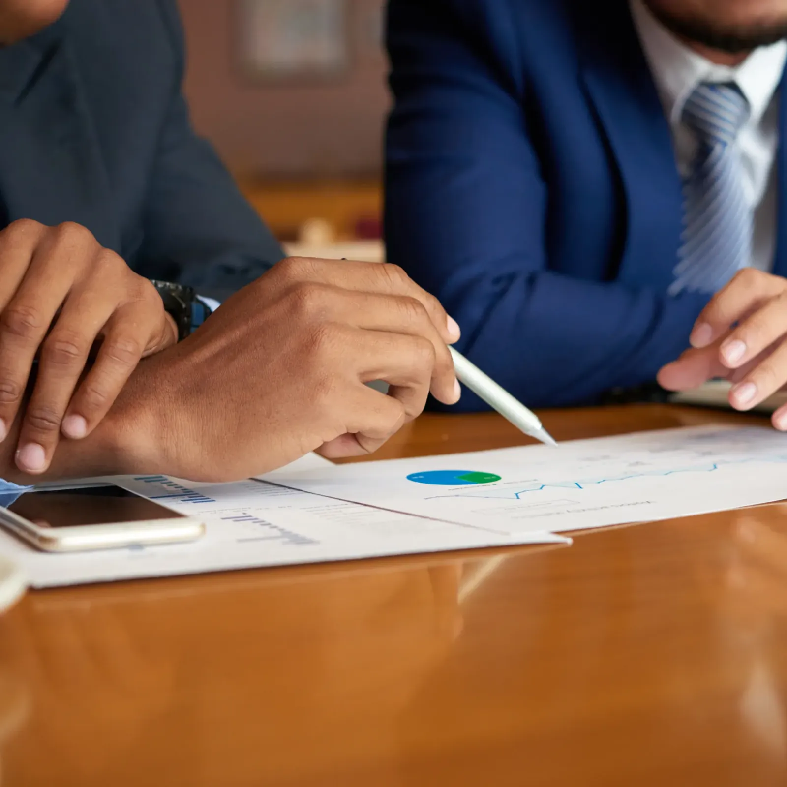 Executivos analisam um relatório com gráficos sobre a mesa de reunião